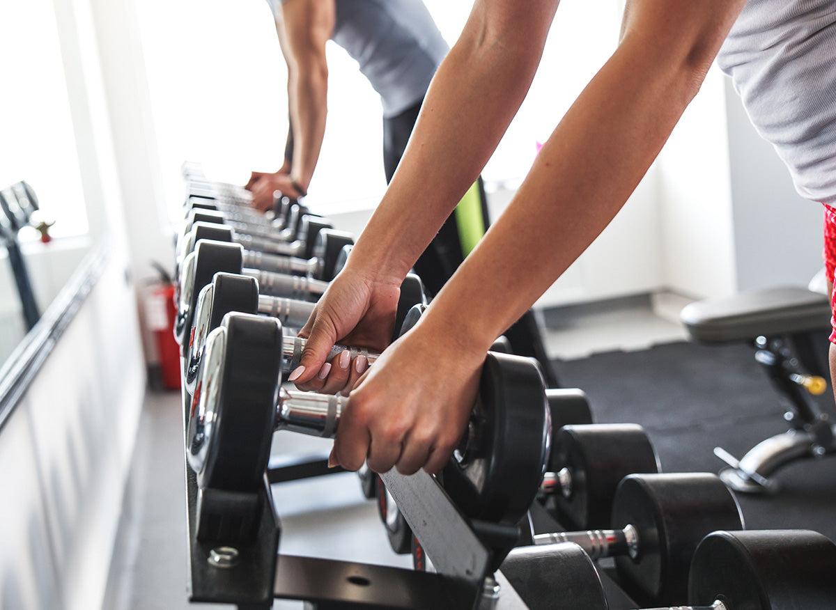 Man picking up dumbbells at the gym.